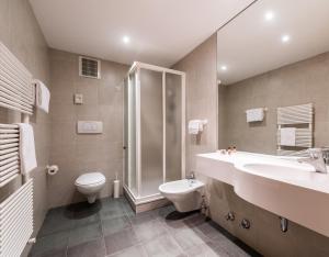 a bathroom with a toilet, sink, and shower at Residence Antares in Selva di Val Gardena