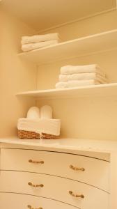 un armario con toallas blancas en un estante en Quintaesencia Hotel Boutique, en Huasca de Ocampo