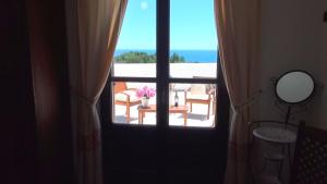 a door leading to a balcony with a vase of flowers at Hotel Resort Nuraghe Arvu in Cala Gonone