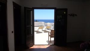 an open door leading to a patio with chairs at Hotel Resort Nuraghe Arvu in Cala Gonone