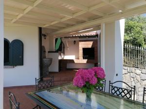 a vase of flowers on a glass table on a porch at Villa Daniela in Riva di Solto