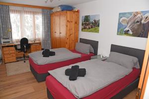 a bedroom with two beds with crosses on them at Monami Apartments Klosters, Apartment 638 Silvretta Parkhotel in Klosters +17 photos
