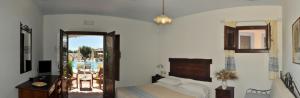 a bedroom with a bed and a balcony at Hotel Resort Nuraghe Arvu in Cala Gonone