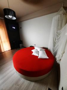 1 cama roja con almohadas blancas en una habitación en karma, en Montecorvino Rovella