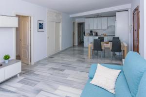 salon z niebieską kanapą i kuchnią w obiekcie Apartamento con vistas al mar en Carboneras w mieście Carboneras