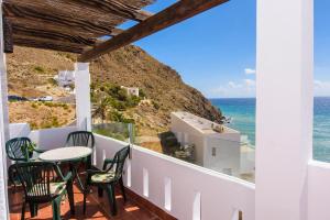 balkon ze stołem i krzesłami oraz oceanem w obiekcie Apartamento con vistas al mar en Carboneras w mieście Carboneras