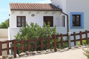 a wooden fence in front of a house at Hotel Resort Nuraghe Arvu in Cala Gonone