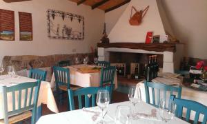 a dining room with tables and chairs with wine glasses at Hotel Resort Nuraghe Arvu in Cala Gonone