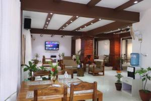 un soggiorno con tavolo, sedie e TV di Heritage Home Dhulikhel a Dhulikhel