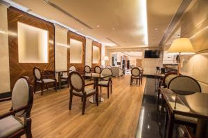 a restaurant with wooden floors and tables and chairs at Hotel Andalucía Center in Granada