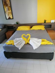 ein Bett mit zwei Handtüchern in Herzform in der Unterkunft Studio le Sucrier in Saint-François