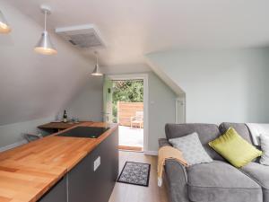 uma sala de estar com um sofá e uma cozinha em Ella's Loft em Canterbury