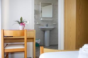 bagno con lavandino, tavolo e specchio di Hotel Serafini a Misano Adriatico