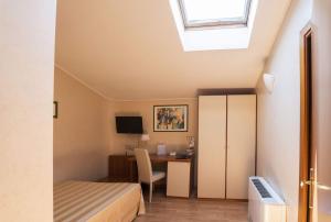 a bedroom with a bed and a desk with a computer at Hotel Cristoforo Colombo in Osimo