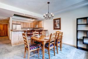 a kitchen and dining room with a wooden table and chairs at Corral at Breckenridge #103E - Private Hot Tub - Close to Town in Breckenridge