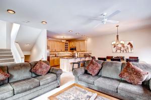 a living room with two couches and a kitchen at Mountaineer #M-1 - Ski-In/Ski-Out - Private Outdoor Hot Tub in Breckenridge