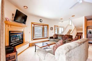 sala de estar con sofá y chimenea en Mountaineer #M-1 - Ski-In/Ski-Out - Private Outdoor Hot Tub, en Breckenridge