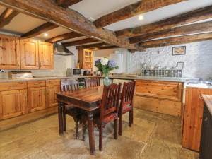 ピカリングにあるCherry Tree Cottageのキッチン(木製キャビネット、木製テーブル、椅子付)