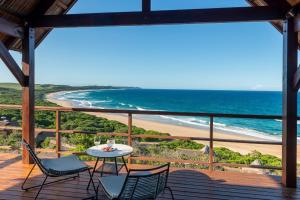 a balcony with a table and chairs and a beach at Montebelo Milibangalala Bay Resort in Maputo