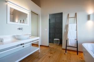 ein weißes Badezimmer mit einem Waschbecken und einem Spiegel in der Unterkunft Montebelo Milibangalala Bay Resort in Maputo