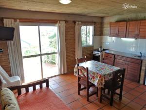 a kitchen with a table and a kitchen with a table and chairs at El Tridente in Punta Del Diablo +61 photos