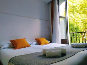 two beds in a room with a large window at Pensión Sarriegi in San Sebastián