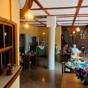 a group of people sitting at tables in a restaurant at Apart Amabile Sul Mare in Villa Gesell