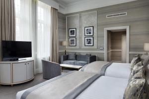 a hotel room with two beds and a flat screen tv at The Midland in Manchester
