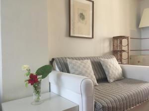 una sala de estar con sofá y un jarrón de flores sobre una mesa en Patio Granada, en Granada
