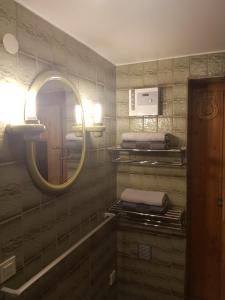 La salle de bains est pourvue d'un miroir et d'un lavabo. dans l'établissement Gemütliche Ferienwohnung mit Kamin und Sauna!, à Nistertal