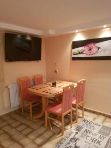 a dining room with a table and chairs and a flat screen tv at Gemütliche Ferienwohnung mit Kamin und Sauna! in Nistertal