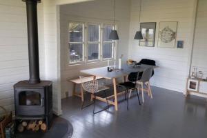 cocina con fogones, mesa y sillas en Panoramic seaview from cottage, en Omø By