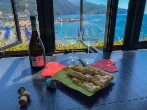 a table with two glasses of wine and a plate of bread at La Casa del Gigante Luxury Collection in Monterosso al Mare