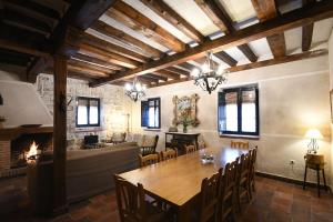 a dining room with a table and a fireplace at El Rincón de Pilar Disfruta de tu escapada rural disfruta de tu casa in Fuentemilanos