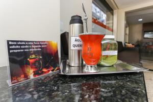 a drink and a thermos sitting on a counter at Hotel Expressinho Aeroporto in Porto Alegre