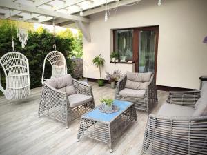 a patio with wicker chairs and a table at Family house in Druskininkai