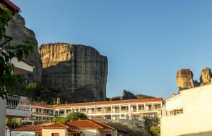a building with a mountain in the background at Toti Boutique Rooms in Kalabaka