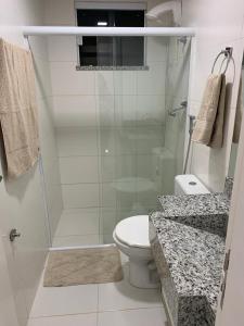 y baño blanco con ducha y aseo. en Condomínio e resort Villa das Águas - Praia do Saco SE, en Estância