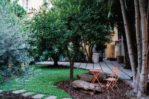 un jardín con mesa, 2 sillas y un árbol en NAP Hostel Spaccanapoli en Nápoles