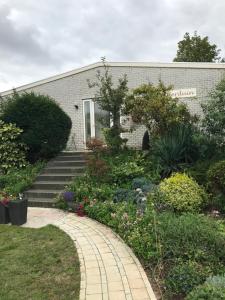 un bâtiment en briques avec une passerelle en face d'un jardin dans l'établissement Villa 't Haasduin, à Wijk aan Zee