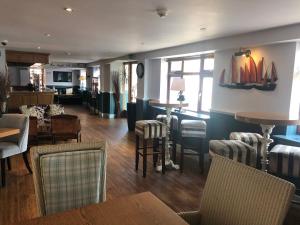 a restaurant with chairs and tables and a bar at The Elm Tree Inn in Wisbech