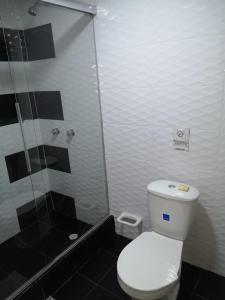 y baño con aseo blanco y ducha. en Hotel Santiago Plaza, en Bogotá