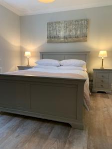 斯冬希文的住宿－Crawfield Grange，一间卧室配有一张大床、两张桌子和两盏灯。