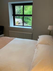 1 cama blanca en un dormitorio con ventana en Crawfield Grange en Stonehaven