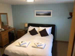 a bedroom with a bed with towels on it at The Elm Tree Inn in Wisbech