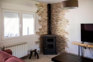a living room with a brick wall and a stove at El Gavilán in Villaviciosa