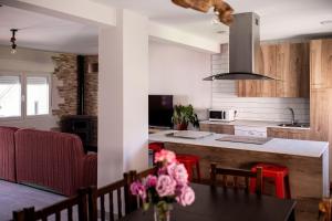 a kitchen and dining room with a table with pink flowers at El Gavilán in Villaviciosa