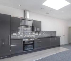 a kitchen with a stove top oven in a room at Premium Apartments Thatcham Broadway in Thatcham
