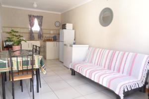 a living room with a couch and a table and a kitchen at Sunrise Cottage in Upington