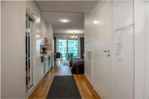 a room with a bed and a hallway with a kitchen at StarHomes Studio Apartments in Oulu
